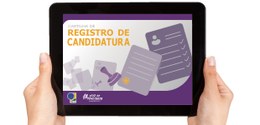 Na foto, uma pessoa branca segura um tablet. Na tela do aparelho, aparece a capa da Cartilha de ...