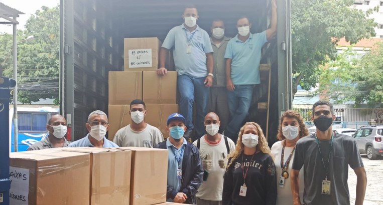 Servidores e colaboradores do TRE-RJ posam ao lado de caixas descarregadas de um caminhão
