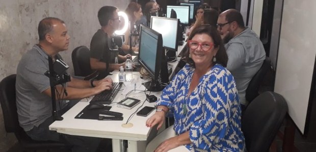 TRE-RJ encerra atendimento itinerante no TJRJ Em primeiro plano, mulher branca, de cabelo curto, posa sentada à frente de guichê de atendiment...