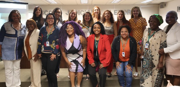 TRE-RJ Enfrentamento à desinformação abre a IV Semana da Diversidade do TRE-RJ Foto de um grupo de mulheres, em sua maioria mulheres negras, em pé em uma sala, de frente para ...