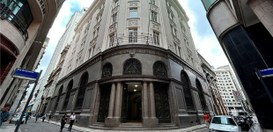 A imagem mostra uma vista de rua em uma área urbana, com um prédio distintivo na esquina. O edif...