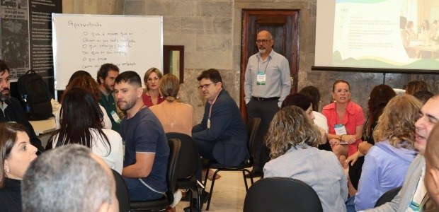 TRE-RJ Gestoras(es) participam de oficinas no segundo dia do 6ª Desenvolve JE grupo de pessoas sentadas em círculo participando de uma dinâmica em ambiente interno, em um eve...