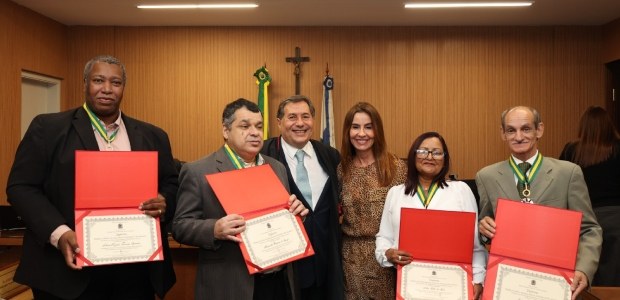 TRE-RJ homenageia eleitores comuns em cerimônia inédita com Medalha do Mérito da Justiça Eleitoral a foto mostra seis pessoas posando juntas no Plenário do TRE-RJ, que tem paredes amadeiradas. No...