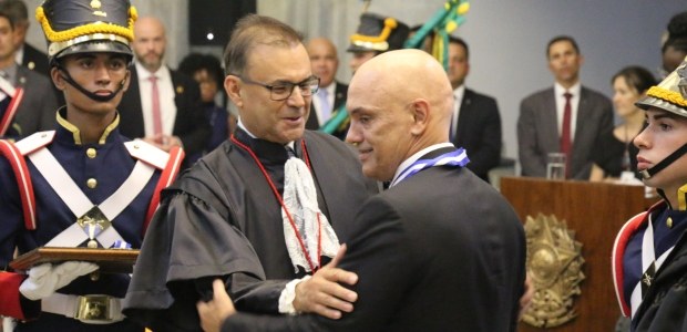 foto do presidente do TRE-RJ, desembargador Elton Leme, colocando a medalha no presidente do TSE...