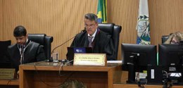 Durante a sessão de julgamento, o presidente do TRE-RJ está com toga sentado em uma cadeira elev...