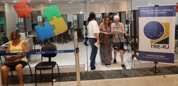 TRE-RJ inicia atendimento itinerante no ParkShoppingCampoGrande A imagem mostra a entrada do espaço onde aconteceu o atendimento itinerante do TRE-RJ. Um painel...