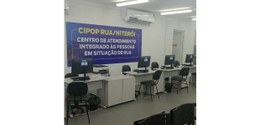 O local de atendimento da Justiça Eleitoral fluminense no Cipop-Rua. Na parede, há um banner esc...