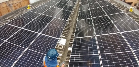 foto de funcionário instalando placas solares no telhado 