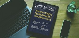 Tablet com a capa da nova edição da revista ‘’Justiça Eleitoral em Debate’’ posicionado sobre um...