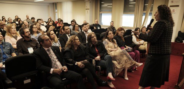TRE-RJ Palestra sobre comunicação não-violenta é destaque do último dia do Desenvolve JE no Rio A secretária de gestão de pessoas está falando ao microfone diante de uma plateia atenta no audi...