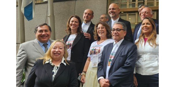 Onze autoridades, entre elas o presidente do TRE-RJ, de terno cinza, estão sorrindo e de pé, dur...