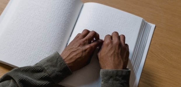 TRE-RJ participará de celebração do Dia Nacional de Luta da Pessoa com Deficiência foto das mãos de uma pessoa que lê um livro em Braille