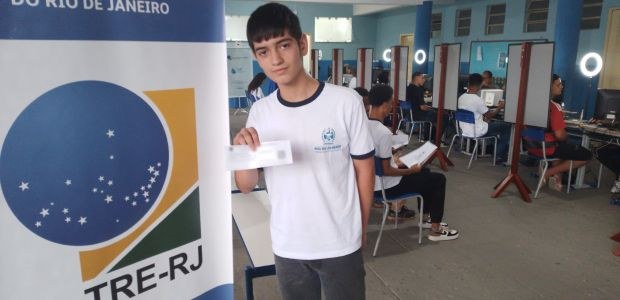 TRE-RJ #PartiuVotar aumenta em 35% o eleitorado jovem de São José do Vale do Rio Preto O estudante Gabriel Michel, rapaz branco, cabelos pretos e curtos, usando uniforme da escola com...
