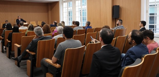 TRE-RJ pede participação dos partidos no combate à violência política Auditório com pessoas sentadas assistindo o presidente do TRE-RJ falar ao lado do coordenador do...