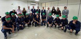 Magistradas(os) e servidoras(es) estão de pé, lado a lado, sorrindo para a foto. Na frente e aga...
