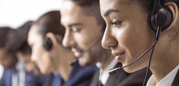 TRE-RJ promove painéis sobre a importância das Ouvidorias A imagem mostra um grupo de pessoas em um ambiente de call center. O foco está em uma mulher no ...