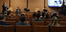No auditório do Palácio da Democracia, ha várias pessoas assistindo a apresentação. Sentados na ...