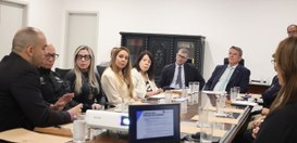 Autoridades estão sentadas em volta de uma mesa durante a reunião do projeto “Democracia Além da...
