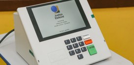 Urna eletrônica em cima de uma mesa redonda