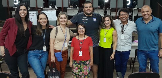 Oito pessoas posam lado a lado para a foto